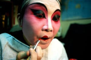 A Bhutanese woman applies traditional face paint