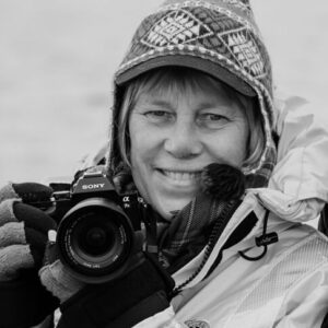 Black and white image of Better Moments Expert Sisse Brimberg with her camera