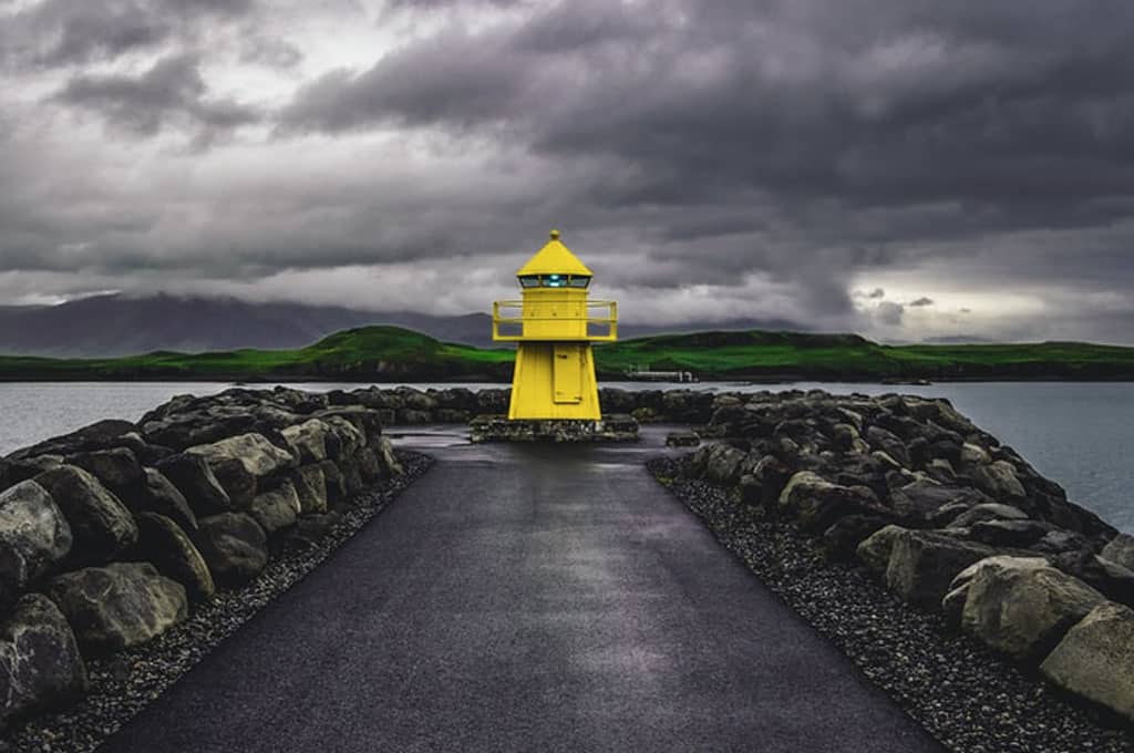 A lone yellow lighthouse on a cloudy day in Iceland's capital Reykjavik