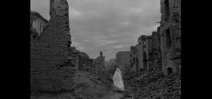 Veiles woman walks through ruins, Afghanistan