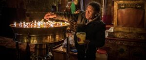 Buddhist Pilgrims light candles in one of the many and historic temples of Tibet Lhasa, China.