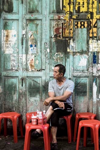 A man is waiting for his food order in one of the many street kitchens