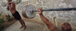 Two Thai man are weight lifting in a backyard
