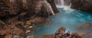 Photographer standing next to a waterfall in Iceland / landscape Iceland by Christian Nørgaard