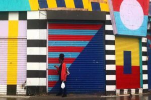 Woman walks in front a colourful storefront in Hackney, London