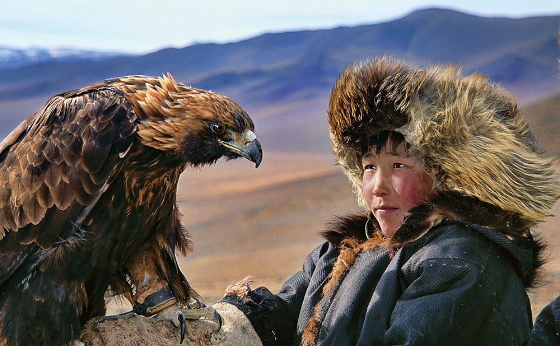 Boy with the eagle in Mongolian mountain background by Hamid Sardar