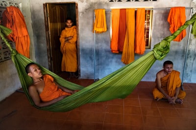 Monks relaxing in green hammock