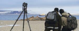 Walruses in Svalbard are lying and sleeping while photographers capture them with their ship in the background during a Better Moments wildlife workshop, led by CEO and founder of Better Moments, photographer Christian Nørgaard.